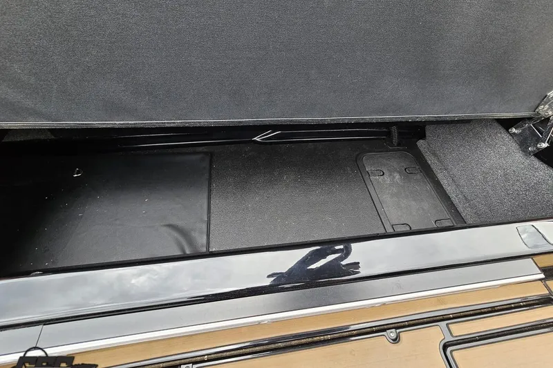 Slide: The Image of 2022 Supra SE 550 storage compartment with black interior and carpeted sides. - 56