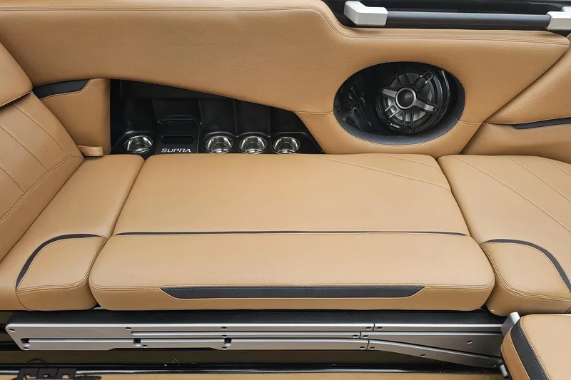 Slide: The Image of 2022 Supra SE 550 interior with tan leather seats and built-in speaker system. - 57
