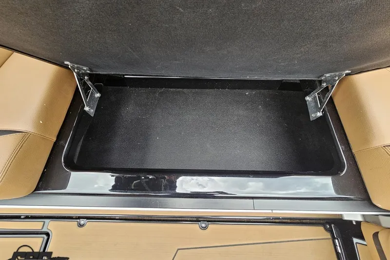 Slide: The Image of Open storage compartment in 2022 Supra SE 550 boat with brown seating. - 58