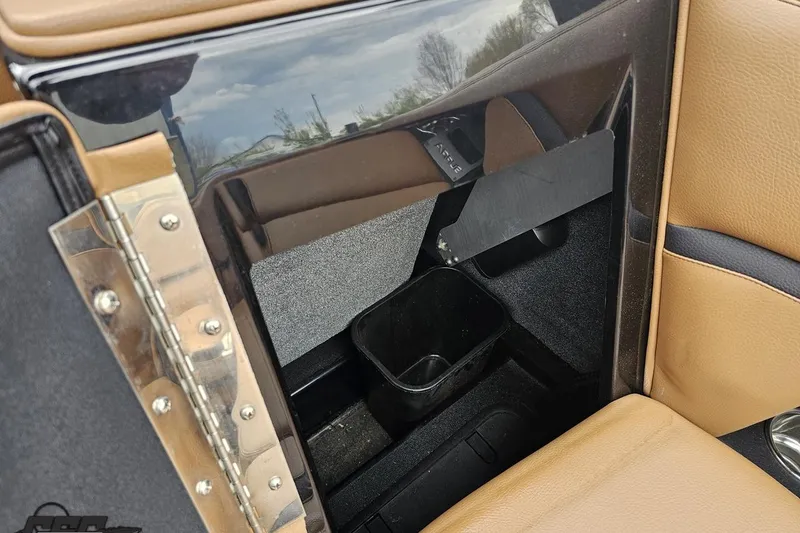 Slide: The Image of Interior view of 2022 Supra SE 550 boat, featuring tan upholstery and storage compartment. - 59