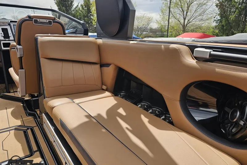 Slide: The Image of 2022 Supra SE 550 boat interior with tan leather seating and speaker system. - 63