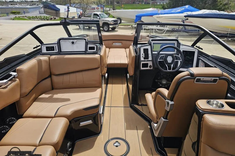 Slide: The Image of 2022 Supra SE 550 boat interior with tan leather seating and modern dashboard. - 65