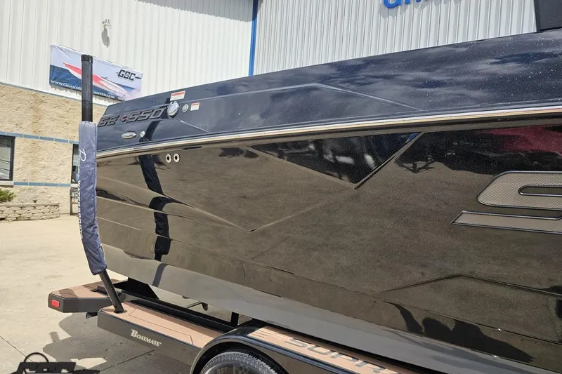 Slide: The Image of 2022 Supra SE 550 boat exterior, sleek black design, parked outside a building. - 7