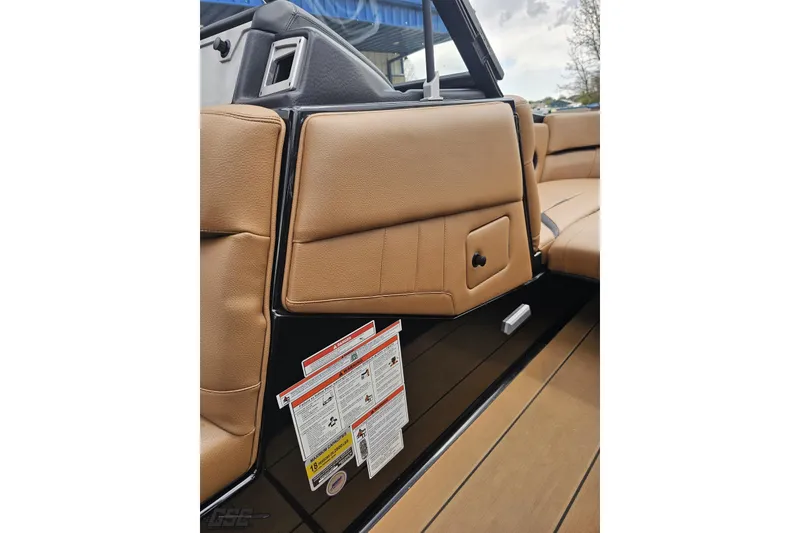 Slide: The Image of 2022 Supra SE 550 interior with tan leather seating and safety labels. - 82