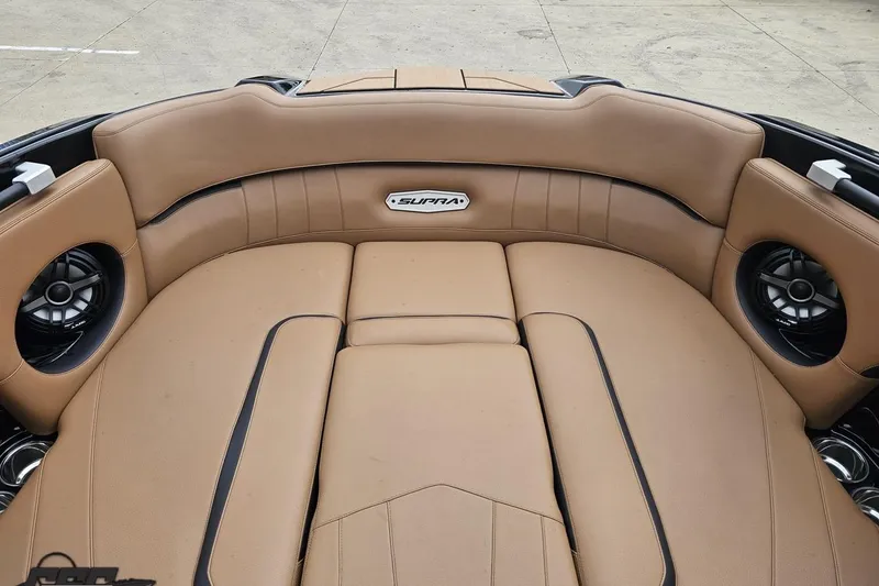 Slide: The Image of 2022 Supra SE 550 boat interior with tan leather seating and built-in speakers. - 91