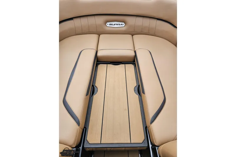 Slide: The Image of 2022 Supra SE 550 boat interior with tan leather seating and wood accents. - 92