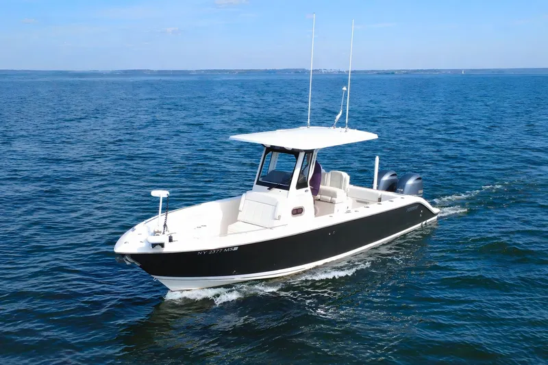 The Image of 2021 Pursuit S 268 Sport boat cruising on open water under clear skies. - 0