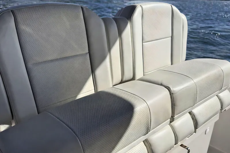 Slide: The Image of 2021 Pursuit S 268 Sport boat seats with gray upholstery on a sunny day. - 11