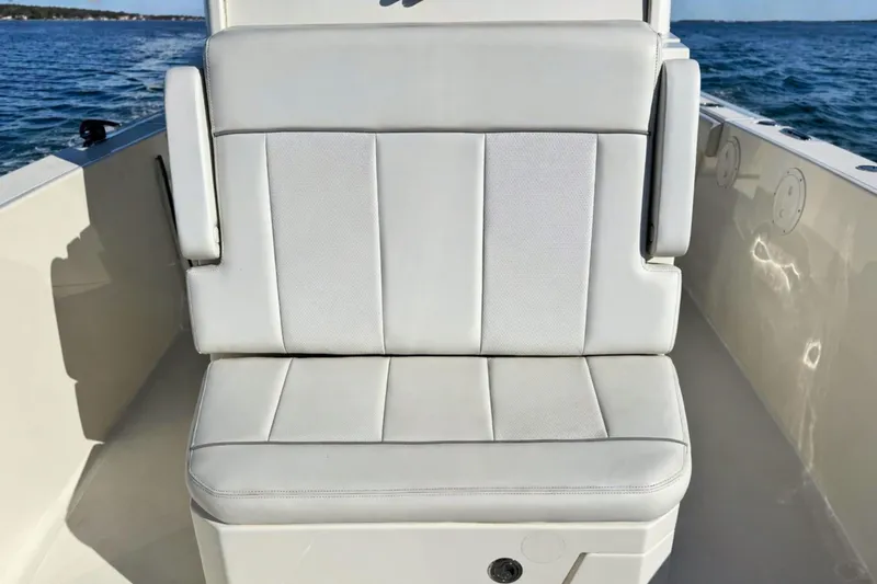 Slide: The Image of White cushioned seat on 2021 Pursuit S 268 Sport boat, with ocean backdrop. - 15