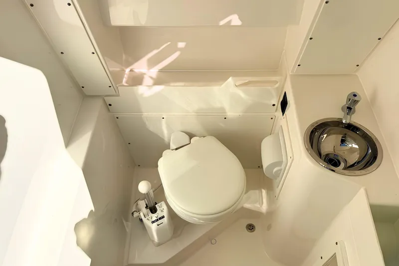 Slide: The Image of 2021 Pursuit S 268 Sport boat bathroom with toilet and stainless steel sink. - 17