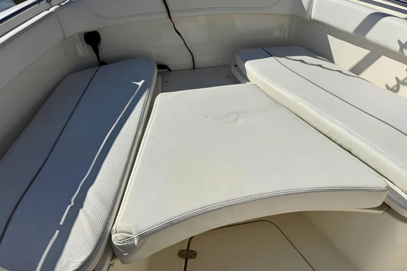 Slide: The Image of Interior seating of 2021 Pursuit S 268 Sport boat, featuring white cushioned seats. - 18