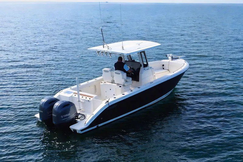 Slide: The Image of 2021 Pursuit S 268 Sport boat on calm ocean waters, featuring dual Yamaha engines. - 2