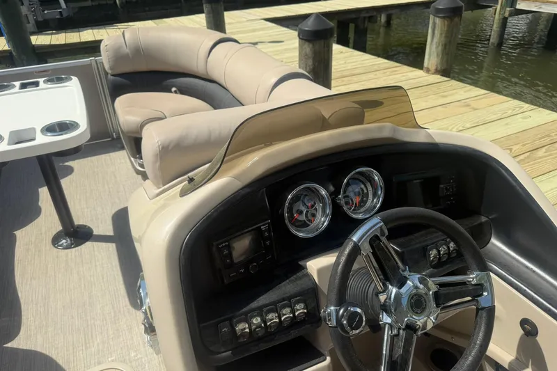 Slide: The Image of 2018 Avalon Catalina Funship Platinum boat interior with steering wheel and seating area. - 14