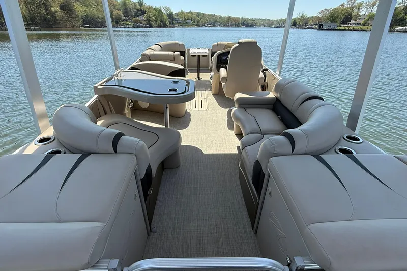 Slide: The Image of 2018 Avalon Catalina Funship Platinum pontoon boat interior with luxurious seating on a serene lake. - 24