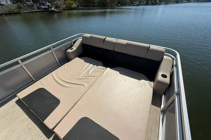 Slide: The Image of 2018 Avalon Catalina Funship Platinum boat with spacious sun deck on a serene lake. - 26