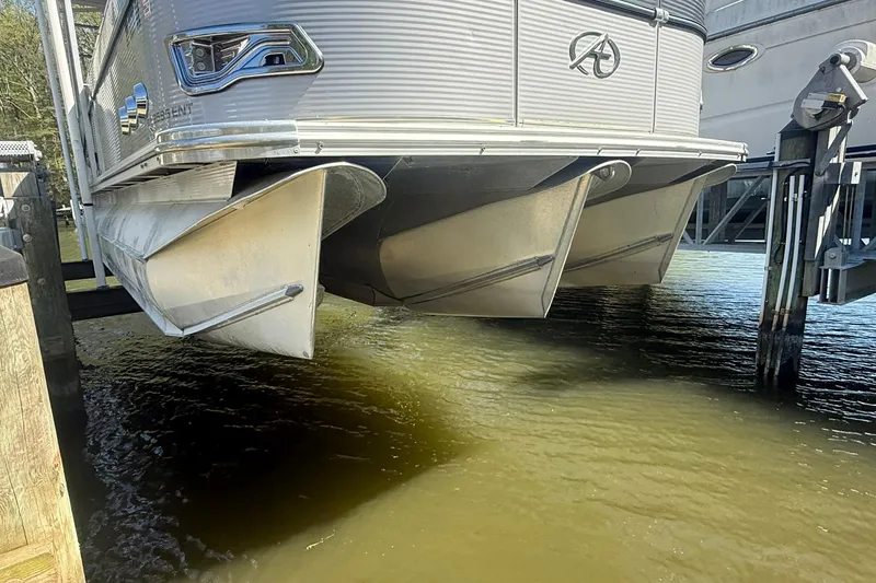 Slide: The Image of 2018 Avalon Catalina Funship Platinum pontoon boat on a lift above water. - 35