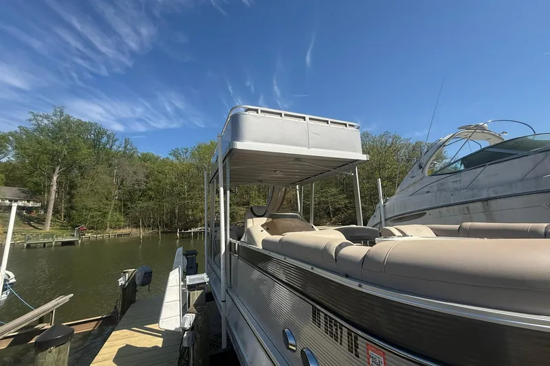 Slide: The Image of 2018 Avalon Catalina Funship Platinum pontoon boat docked by a serene lakeside. - 36