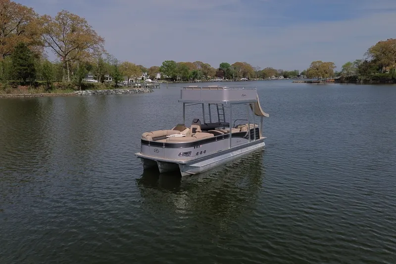 Slide: The Image of 2018 Avalon Catalina Funship Platinum pontoon boat on a serene lake with lush surroundings. - 4