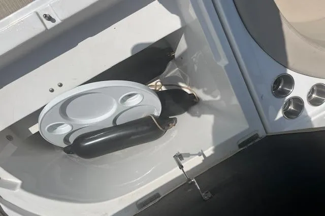 Slide: The Image of 2015 Rinker 276 Captiva Cuddy boat storage compartment with cup holders and accessories. - 11