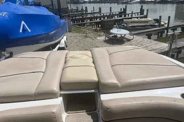 Slide: The Image of 2015 Rinker 276 Captiva Cuddy boat with beige seating, dockside view. - 12