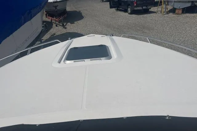 Slide: The Image of 2015 Rinker 276 Captiva Cuddy boat deck with hatch, parked outdoors. - 13