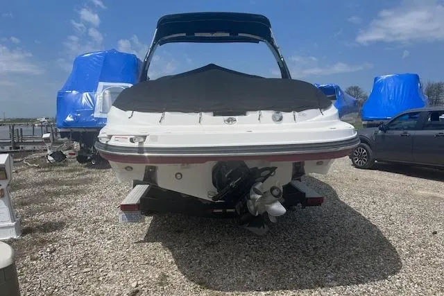 Slide: The Image of 2015 Rinker 276 Captiva Cuddy boat on trailer, covered, with blue tarps in background. - 3
