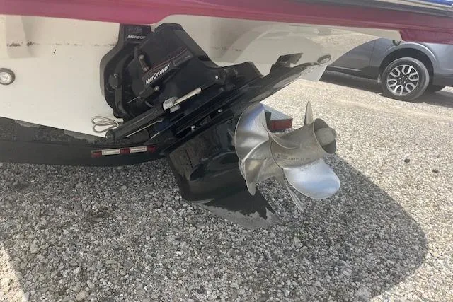 Slide: The Image of 2015 Rinker 276 Captiva Cuddy boat propeller and stern drive on gravel surface. - 4