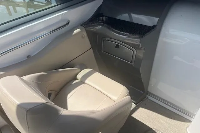 Slide: The Image of 2015 Rinker 276 Captiva Cuddy interior with beige seating and storage compartment. - 6