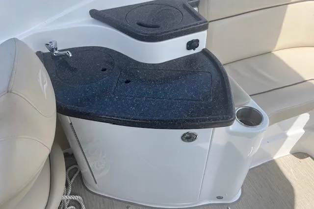 Slide: The Image of 2015 Rinker 276 Captiva Cuddy boat interior with sink and seating area. - 7