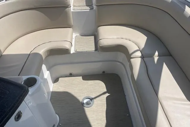 Slide: The Image of 2015 Rinker 276 Captiva Cuddy interior with beige seating and carpeted floor. - 8