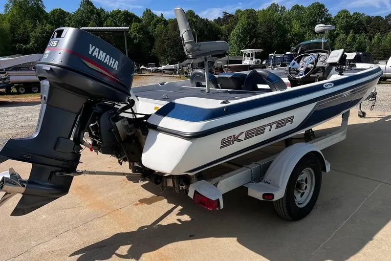 Slide: The Image of 1999 Skeeter SX170 boat with Yamaha motor on trailer, parked outdoors. - 2