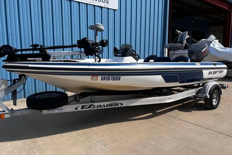Slide: The Image of 1999 Skeeter SX170 boat on EZ Loader trailer, parked outside blue building. - 6