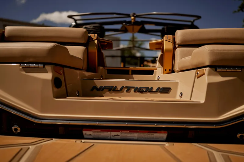 Slide: The Image of 2025 Nautique Super Air Nautique G25 Paragon boat, rear view, luxurious seating, sunny day. - 10