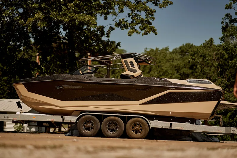 Slide: The Image of 2025 Nautique Super Air Nautique G25 Paragon boat on trailer, outdoors. - 5