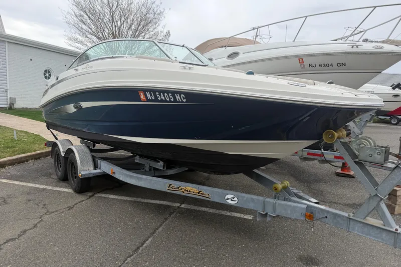 The Image of 2009 Sea Ray 210 Sundeck boat on trailer in parking lot. - 1