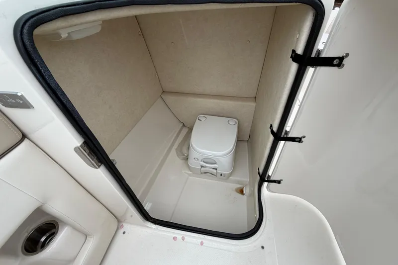 Slide: The Image of 2009 Sea Ray 210 Sundeck boat interior with compact marine toilet. - 10