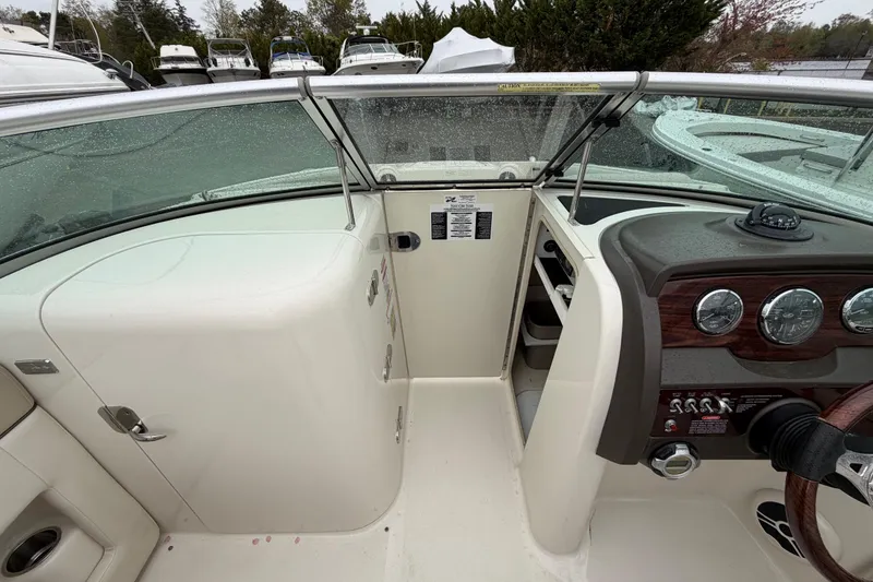 Slide: The Image of 2009 Sea Ray 210 Sundeck cockpit with steering wheel and instrument panel. - 12