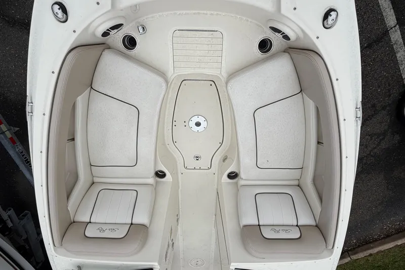 Slide: The Image of 2009 Sea Ray 210 Sundeck boat interior with white seating and cup holders. - 14