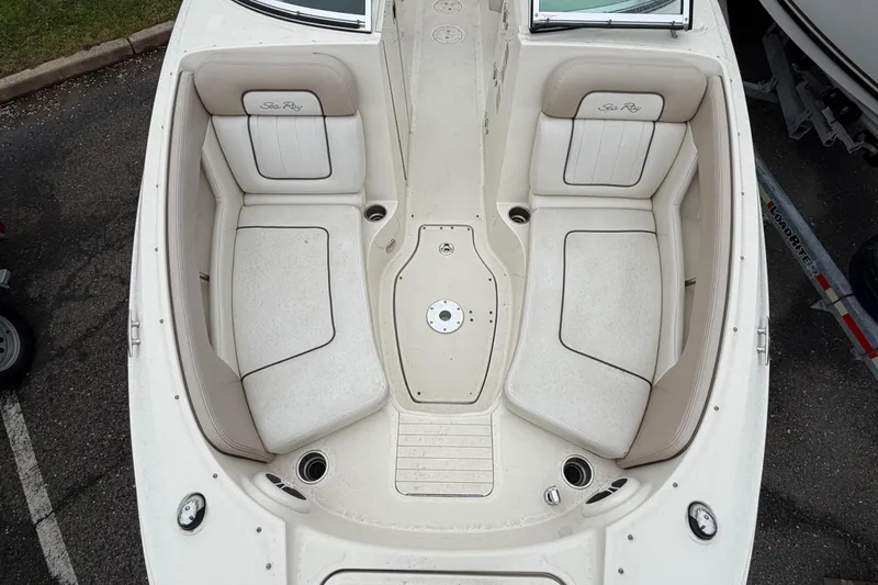 Slide: The Image of 2009 Sea Ray 210 Sundeck boat interior with white seating and cup holders. - 15
