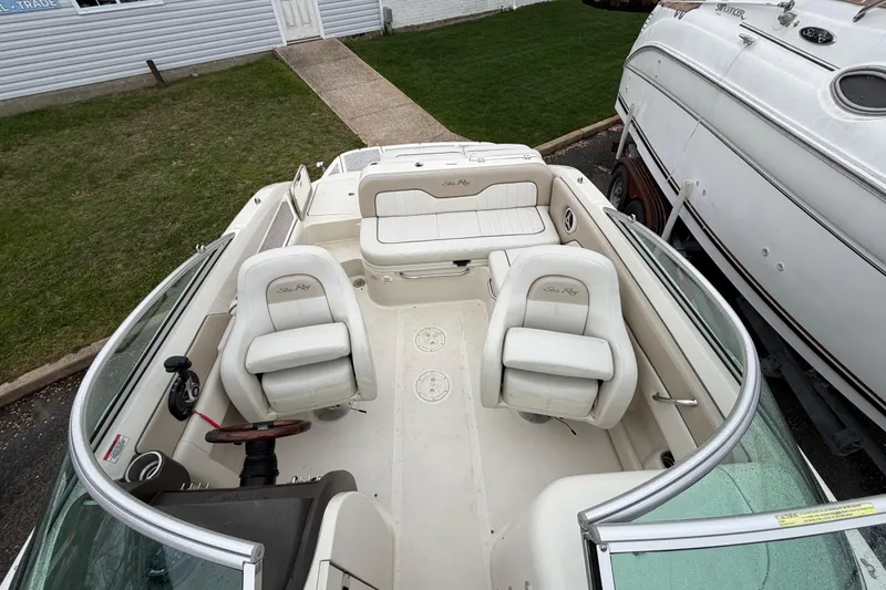 Slide: The Image of 2009 Sea Ray 210 Sundeck boat interior with white seating and steering wheel. - 17