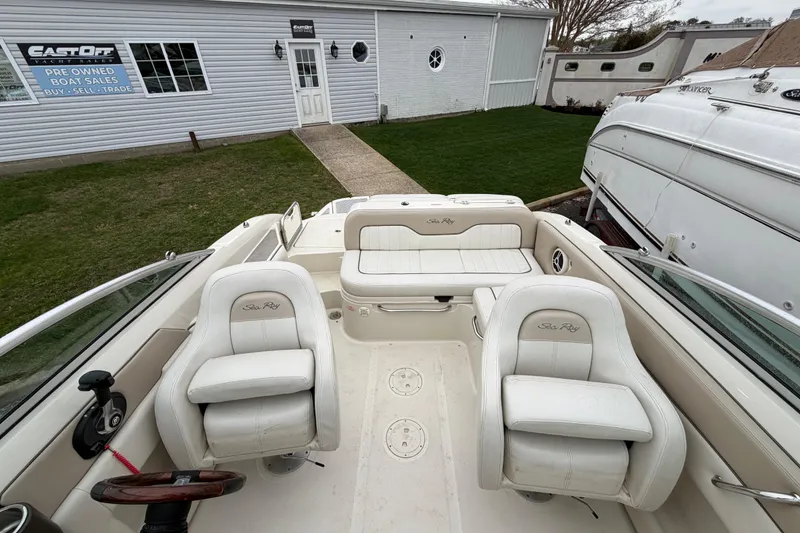Slide: The Image of 2009 Sea Ray 210 Sundeck interior with white seating at a boat sales location. - 18
