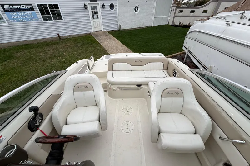 Slide: The Image of 2009 Sea Ray 210 Sundeck interior with white seating at a yacht sales location. - 19