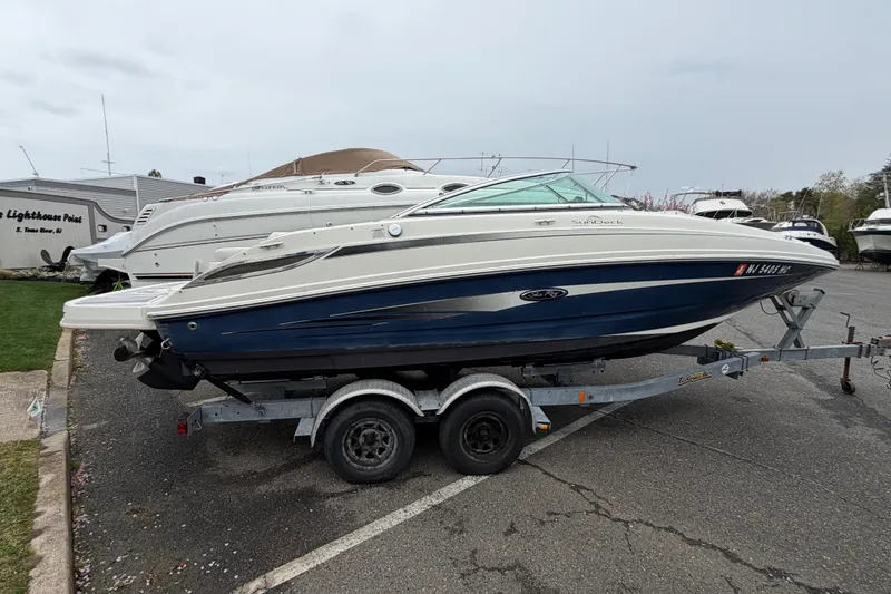Slide: The Image of 2009 Sea Ray 210 Sundeck boat on trailer in marina parking lot. - 3