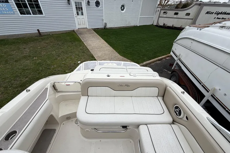 Slide: The Image of 2009 Sea Ray 210 Sundeck boat interior with white seating and speaker detail. - 8
