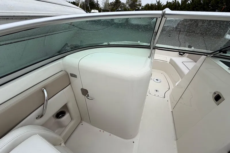 Slide: The Image of 2009 Sea Ray 210 Sundeck interior with wet windshield and seating area. - 9