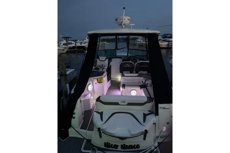 Slide: The Image of 2013 Monterey 340 Sport Yacht docked at night with illuminated interior. - 6