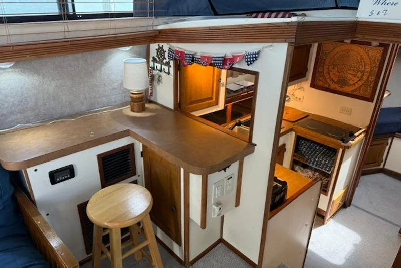 Slide: The Image of Interior of a 1978 Mainship 34 Trawler with cozy kitchen and seating area. - 17