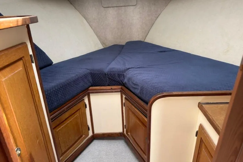 Slide: The Image of Cozy cabin interior of 1978 Mainship 34 Trawler with blue bedding and wooden cabinets. - 20