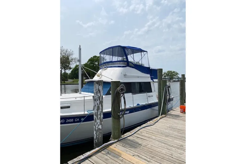 Slide: The Image of 1978 Mainship 34 Trawler docked at a marina with blue canopy. - 4