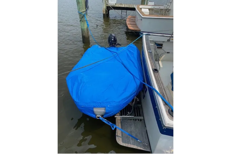 Slide: The Image of Blue-covered dinghy tied to a 1978 Mainship 34 Trawler at a dock. - 7